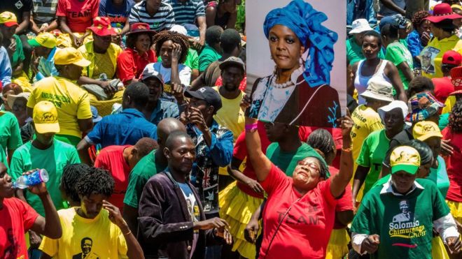 Женщина держит портрет Грейс Мугабе во время сбора сторонников президента в его партийном штабе, чтобы показать поддержку Грейс Мугабе, которая станет следующим вице-президентом партии после отставки Эмерсона Мнангагвы 8 ноября 2017 года