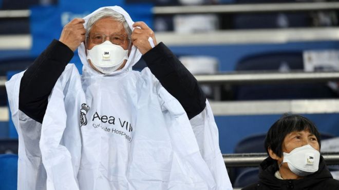 Fans wear 3M Aura Disposable Respirators as they await kickoff prior to the Liga match