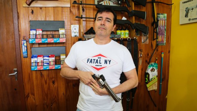 Энрике Ногейра позирует с пистолетом