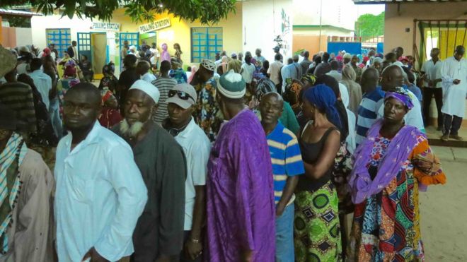 Избиратели стоят в очереди на избирательном участке в Гамбии