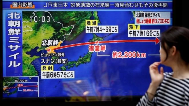 Прохожий смотрит на экран телевизора, сообщающий новости о запуске ракет Северной Кореей в Токио (15 сентября 2017 года)