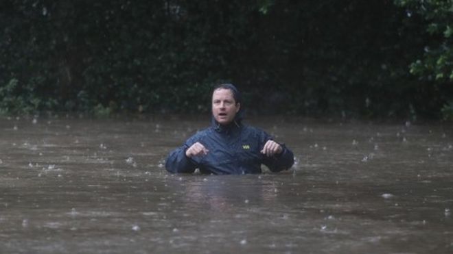 A resident walks down a flooded street in the upscale River Oaks neighbourhood of Houston after it was inundated with water from Hurricane Harvey (27 August 2017)