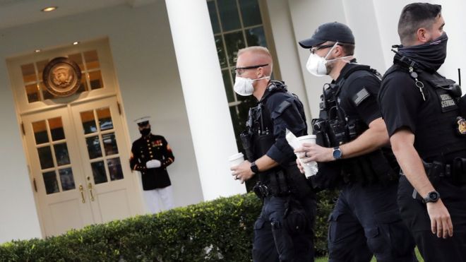Морской пехотинец и сотрудники Секретной службы США видны за пределами Западного крыла после возвращения президента США Дональда Трампа в Овальный кабинет в Вашингтоне, округ Колумбия, 8 октября 2020 г.