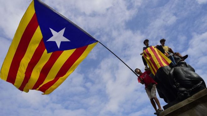 Manifestantes con una enorme bandera catalana independentista en Barcelona.