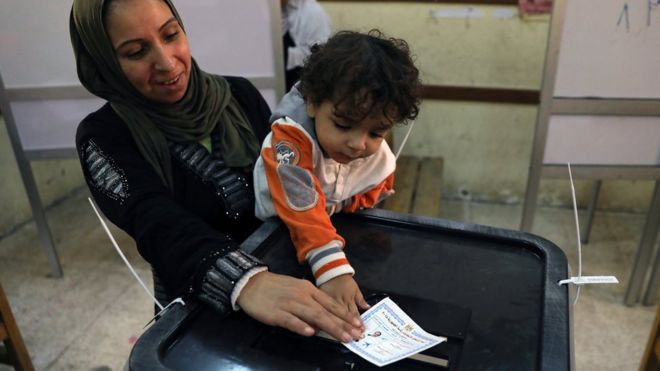 Египетская женщина и ее ребенок проголосовали на президентских выборах в Каире 26 марта 2018 года