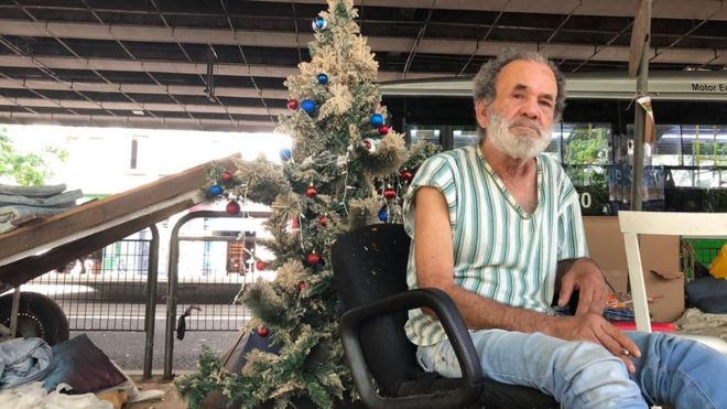 O carroceiro Ubiratan Cipriano e, ao fundo, sua árvore de Natal embaixo do Minhocão