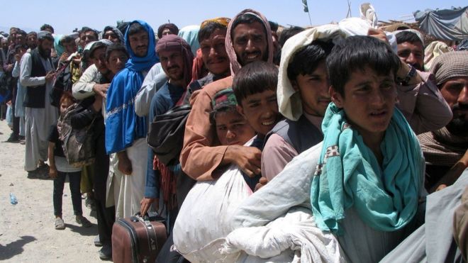 Civiles afganos esperan cruzar la Puerta de la Amistad en el pueblo fronterizo de Chaman, Pakistán, 13 de agosto de 2021