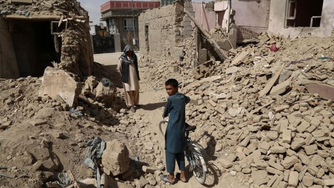 Un hombre y un niño afganos en medio de casas destruidas tras el ataque talibán en Ghazni el pasado mes de agosto.