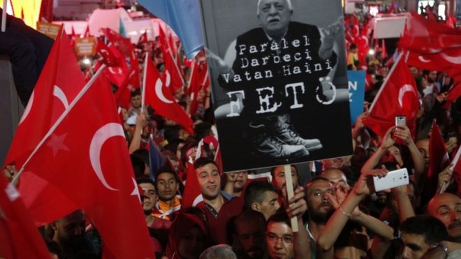 Сторонники президента Турции Реджепа Тайипа Эрдогана машут национальными флагами и держат в руках портрет Фетхуллаха Гюлена