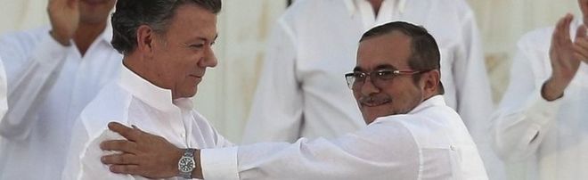 Президент Хуан Мануэль Сантос (слева) и главный командир Фарка Родриго Лондоно пожимают друг другу руки после подписания мирного соглашения в Картахене, Колумбия