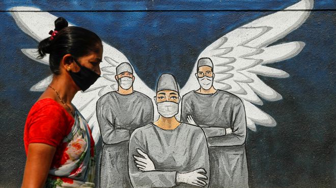 Une personne portant un masque passe une murale