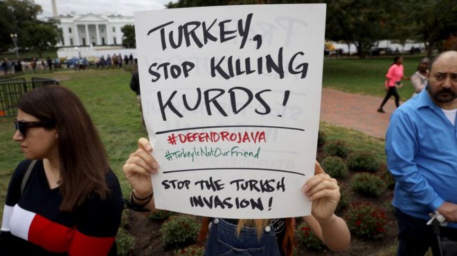 Протестующие против трансграничного наступления Турции на севере Сирии машут знаками у Белого дома в Вашингтоне
