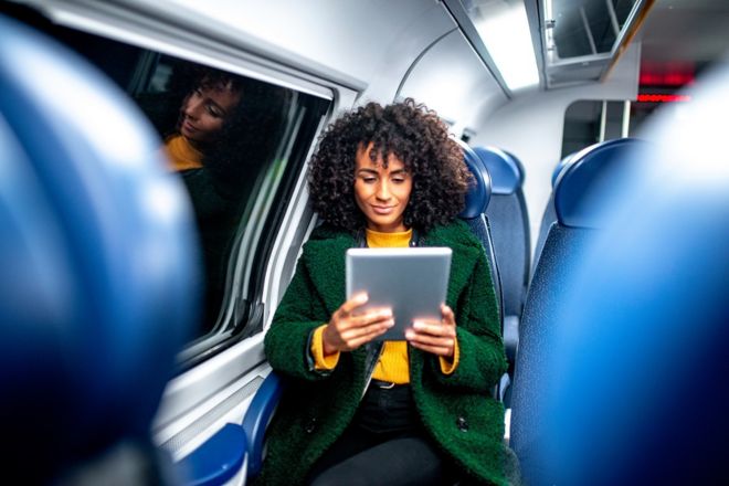 Женщина использует устройство Wi-Fi в поезде