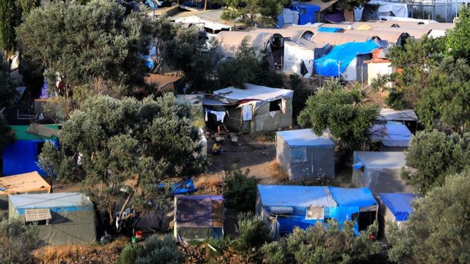 Вид на временный лагерь и официальный лагерь для беженцев и мигрантов над городом Вати на острове Самос, Греция, 1 июля 2019 года