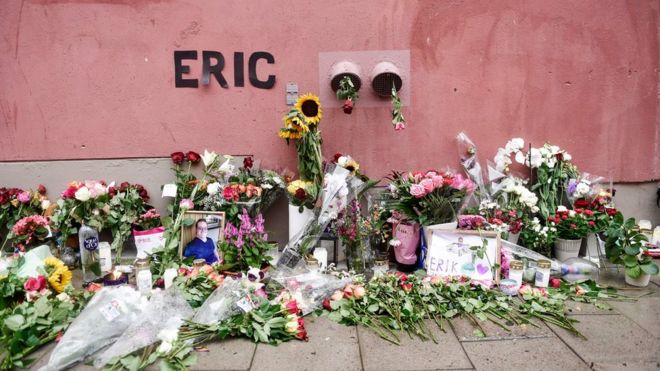 Цветы, свечи и открытки, установленные на месте стрельбы к мемориалу Эрика Торелла