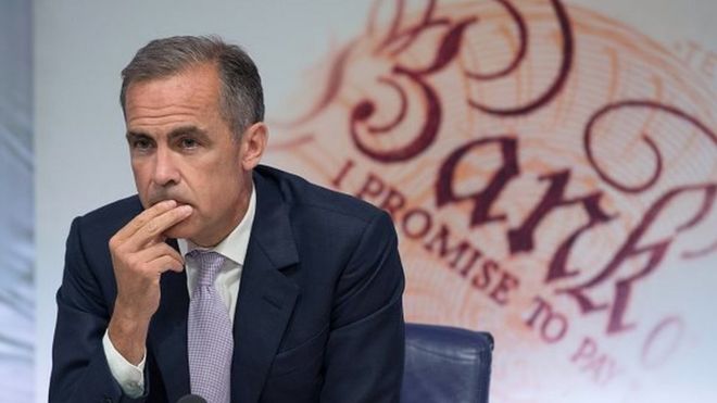 Управляющий Банка Англии Марк Карни смотрит на пресс-конференцию, посвященную квартальному отчету по инфляции