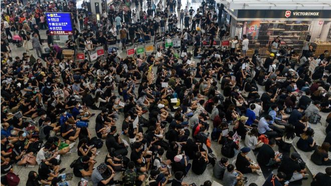 Hong Kong pro-democracy protesters (bottom) block access to the departure gates