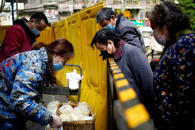 Residents wearing face masks pay for noodles