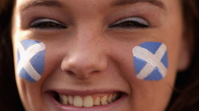 Молодая сторонница Шотландской национальной партии демонстрирует свой патриотизм во время предвыборной кампании с первым министром и лидером Национальной партии Шотландии Николаем Осетриной 4 мая 2015