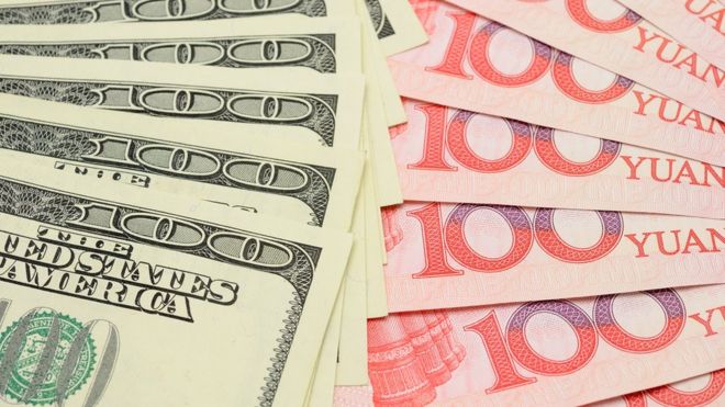 Доллары США и китайские банкноты юаня
