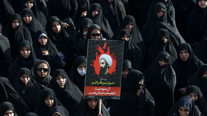 Иранская женщина держит плакат с изображением шейха Нимра аль-Нимра, видного оппозиционного саудовского шиитского священнослужителя, казненного на прошлой неделе Саудовской Аравией, в Тегеране, Иран, в понедельник, 4 января 2016 года.