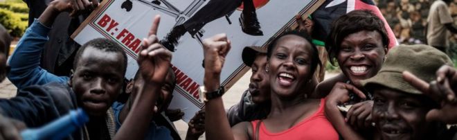 Сторонники держат плакат с изображением президента Ухуру Кеньятты, который празднует 20 ноября 2017 года в Найроби после того, как Верховный суд Кении отклонил две петиции об отмене повторных президентских выборов в стране 26 октября, подтверждающих победу на выборах в Кениату.