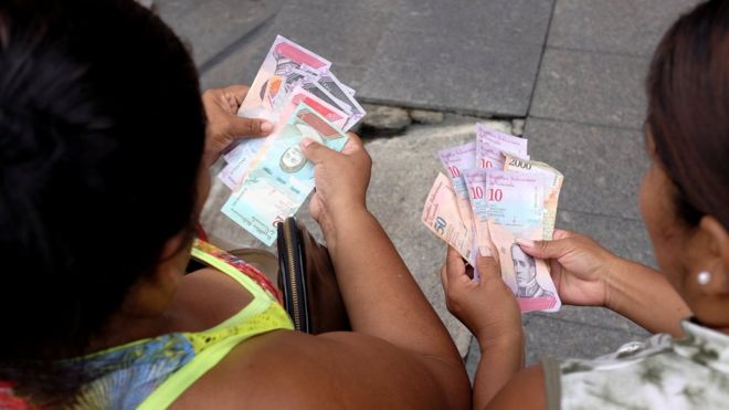 Mujeres con los nuevos billetes de Venezuela