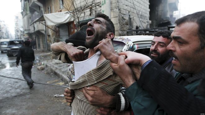 Un père réagit après la mort de deux de ses enfants par un tir d'obus dans le quartier d'al-Ansari, tenu par les rebelles, à Alep, en Syrie (3 janvier 2013).