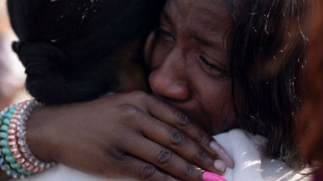 Des femmes pleurent lors d'une veillée après la fusillade de Buffalo.