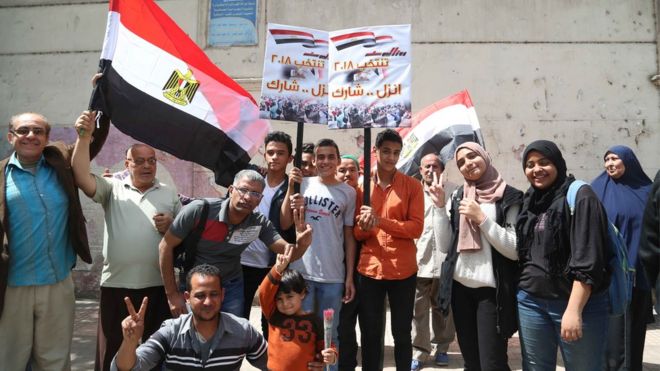 ناخبين يحملون لافتات تحث على المشاركة