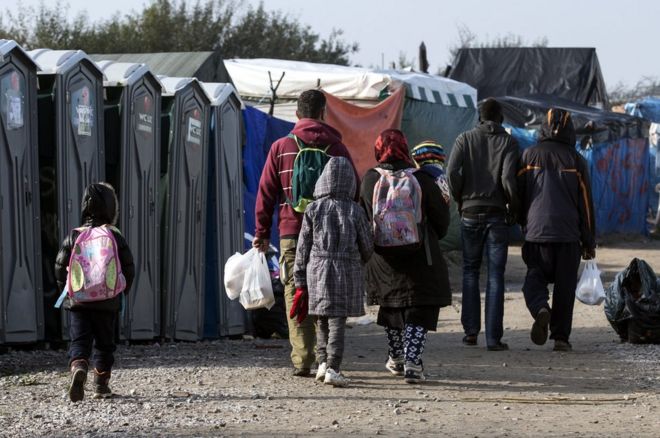 Афганская семья возвращается в центр краткосрочного приема в импровизированном лагере, известном как Джунгли в Кале, Франция, 23 октября 2016 года.