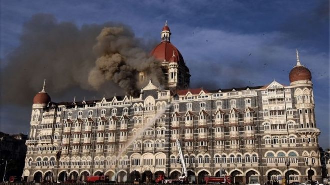 На этом снимке, сделанном 27 ноября 2008 года, индийские пожарные пытаются потушить пожар в виде вздува дыма из отеля Taj Mahal Palace в Мумбаи.