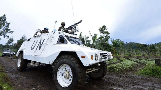 UN peacekeepers in Congo drive in armoured vehicle.