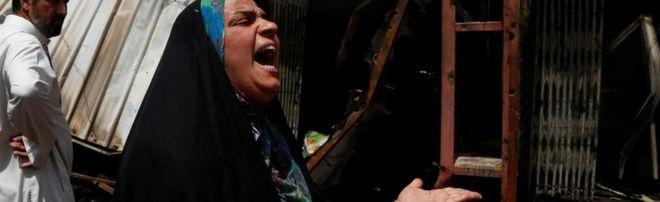 Женщина реагирует на место взрыва автомобильной бомбы в багдадском шиитском районе города Садр