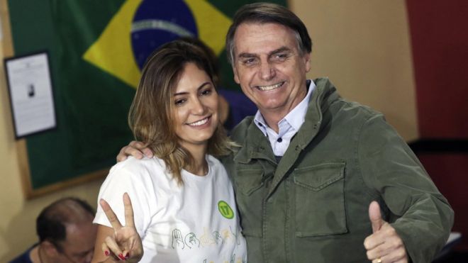 Мистер Болсонаро (справа) и его жена Мишель голосуют в Рио-де-Жанейро