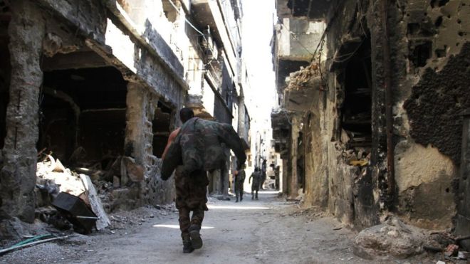 A man walks down a war-damaged street in the Yarmouk refugee camp in Damascus (6 April 2015)