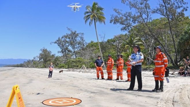 Австралийская полиция и аварийные работники управляют беспилотниками во время поисков на пляже в Квинсленде