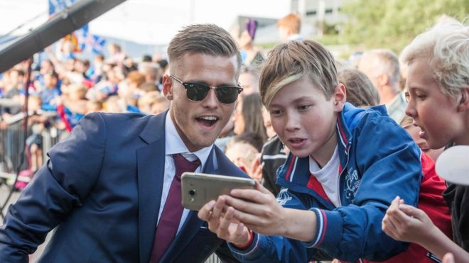 Iceland's midfielder Arnor Ingvi Traustason poses for photograph as he arrives with his team in Reykjavik on July 4, 2016 while people in the street