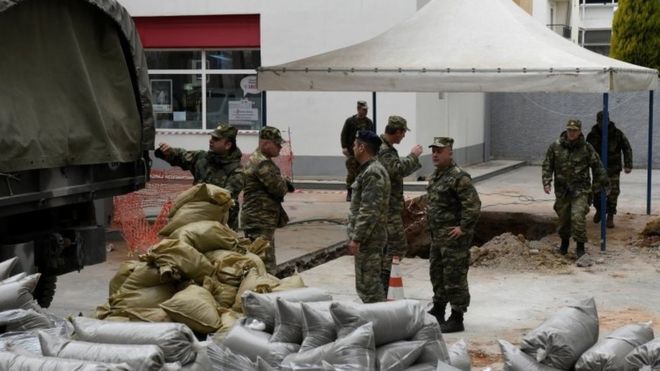 Военные офицеры выгружают мешки с песком рядом с дырой в земле (где в Салониках была обнаружена бомба времен Второй мировой войны (10 февраля 2017 года)