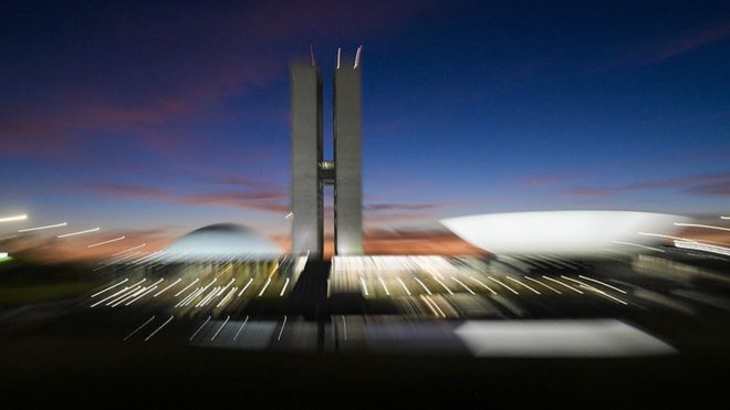 Foto desfocada mostra prédio do Congresso em Brasília no anoitecer