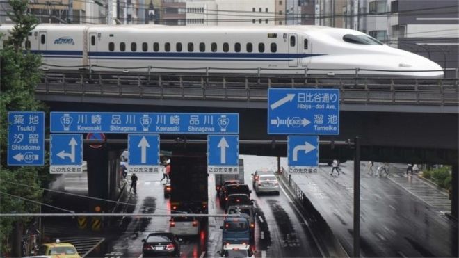 Сверхскоростной пассажирский экспресс Синкансэн движется на путях выше движения в Токио 14 августа 2017 года.