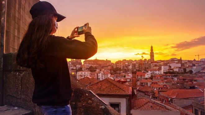 A girl takes pictures of Porto