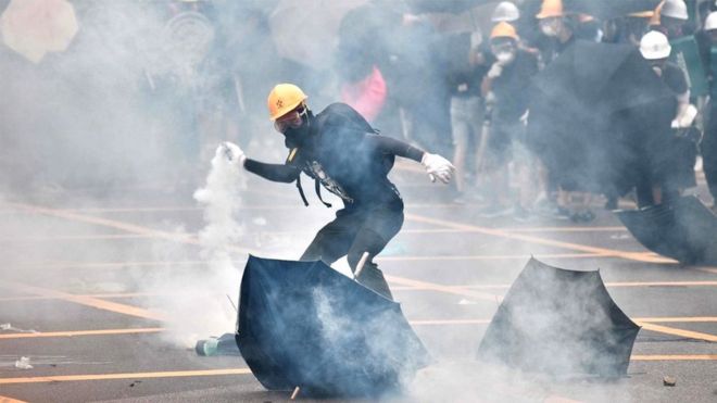 Protester throwing a tear gas can back at the police