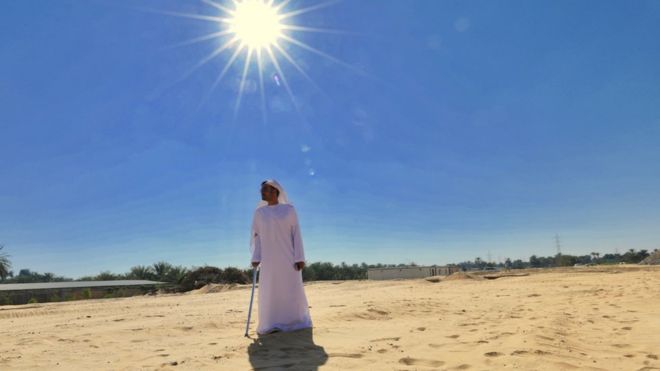 Эмиратский человек, стоящий на солнце пустыни