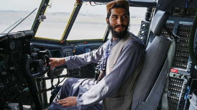 Petempur Taliban berpose di pesawat AS di Bandara Kabul.