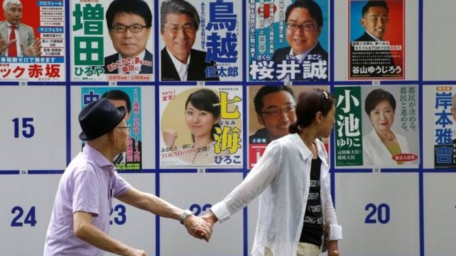 Люди проходят мимо предвыборных плакатов в Токио. Фото: 31 июля 2016 г.