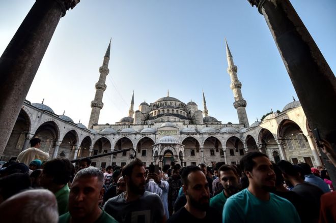 Muslim worshippers leave the Blue Mosque after the Eid al-Fitr prayers in Istanbul, 25 June