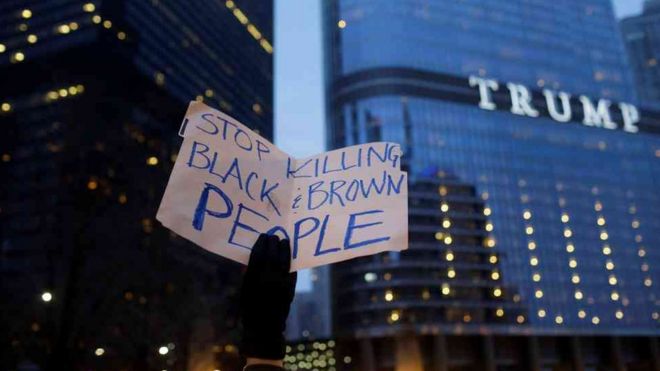 Placard saying "stop killing black and brown people" in front of Trump tower