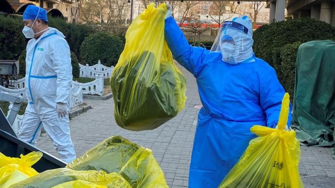 workers remove medical waste from building where people quarantine at home 05/12