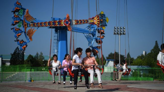 Люди наслаждаются поездками в парк развлечений Rungra People's, Пхеньян